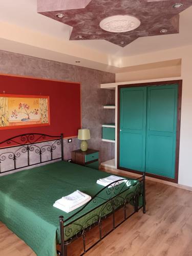 um quarto com uma cama verde e uma parede vermelha em Lu Sule B&B em Supersano