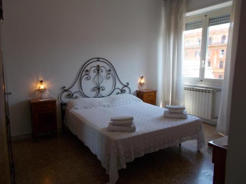 um quarto com uma cama branca e toalhas em B&B Tiber em Roma