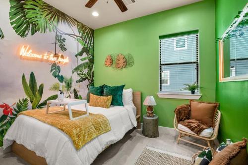 ein grünes Schlafzimmer mit einem Bett und einem Stuhl in der Unterkunft Prolific Theme Suite Ft Jacuzzi Tub 9Os Fun & Content Spaces in Houston