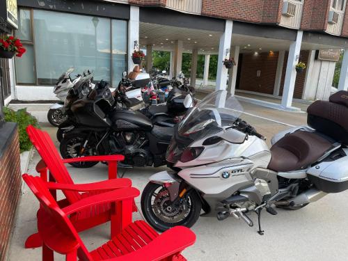 a row of motorcycles parked outside a building with red chairs at Rodd Grand Yarmouth in Yarmouth