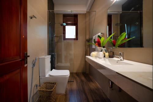 a bathroom with a white toilet and a sink at Kandy Tree Tops in Kandy