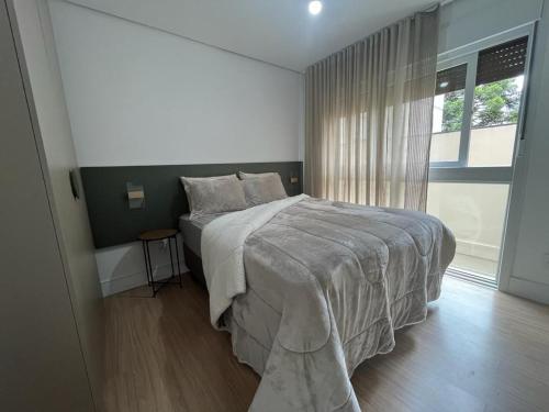 Un dormitorio con una cama grande y una ventana en REFUGIO SERENO PRÓXIMO A CATEDRAL DE CANELA, en Canela