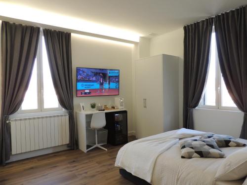 1 dormitorio con 1 cama, escritorio y TV en Cozy Living Bergamo, en Seriate