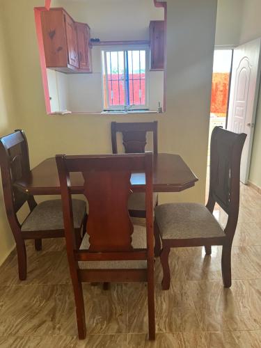 een eettafel met 2 stoelen en een houten tafel bij Residencial Peralta in Pedernales