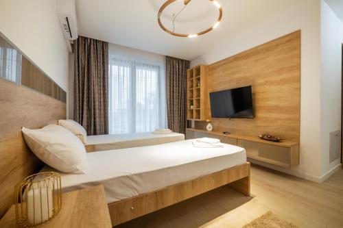 um quarto de hotel com uma cama e uma televisão em Premier Luxury Apartment Lake On em Mamaia