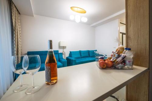 a bottle of wine and two glasses on a counter at Premier Luxury Apartment Lake On in Mamaia