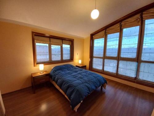 um quarto com uma cama e duas mesas de cabeceira e janelas em La Loma em Cajamarca