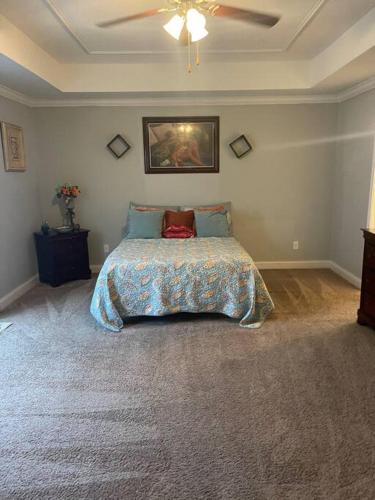 a bedroom with a bed and a painting on the wall at Spacious Home Near Shaw in Sumter