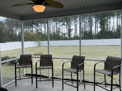 a group of chairs sitting around a table in a porch at Spacious Home Near Shaw in Sumter