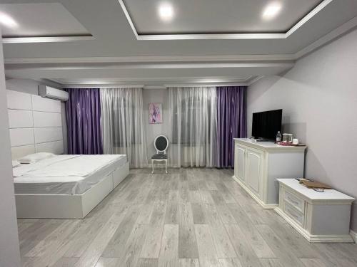 1 dormitorio con 1 cama y TV. en Grand House Hotel & Zipline Kapan, Armenia, en Kapan