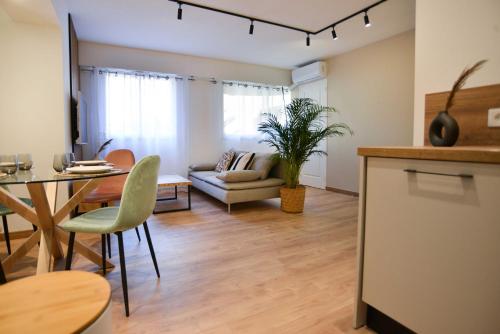 un salon avec une table et un canapé dans l'établissement 50 m plage & tram superbe appart récent, à Nice