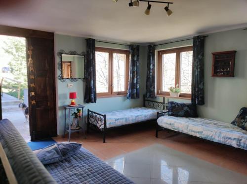 a living room with two couches and windows at Casa di Viu' in Viù