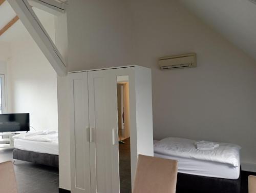 uma sala com um quarto com uma cama e uma televisão em Ferienwohnungen Fabry 2 2 em Saarbrücken