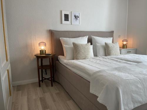 ein Schlafzimmer mit einem großen Bett mit weißer Bettwäsche und Kissen in der Unterkunft Strandzone 29 in Kronsgaard