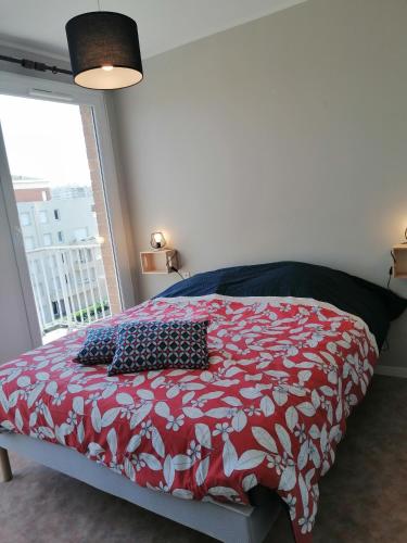 - une chambre avec un lit rouge et blanc et une fenêtre dans l'établissement Les Terrasses de Marcq, à Marcq-en-Barœul