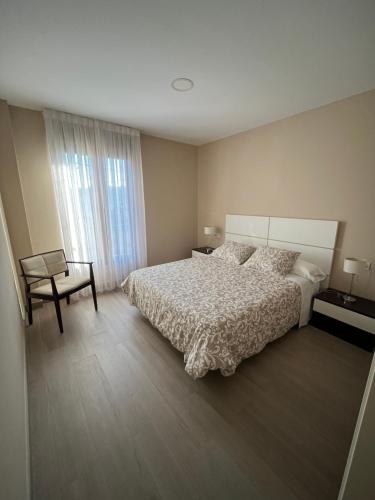 メリーデにあるCasa Victorianoのベッドルーム1室(ベッド1台、椅子、窓付)
