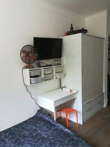 a room with a white desk and a fan at studio rdc bois de vincennes in Saint-Mandé
