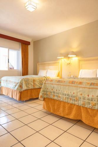 a hotel room with two beds in a room at María Isabel Colima in Colima