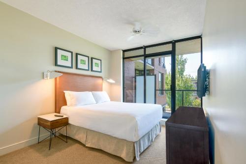 a bedroom with a bed and a large window at Oswego Hotel in Victoria
