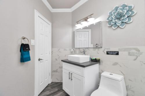 Baño blanco con lavabo y aseo en Prolific Blue Oasis near Med Ctr Dwntwn Galleria en Houston