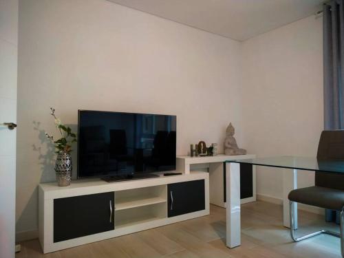 a living room with a television and a table at Apartamento Medina cerca de la Ribera in Córdoba