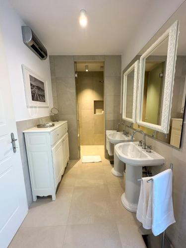 a bathroom with two sinks and two mirrors at Ca' S Lorenz - A Luxury 100m2 Apartment in a Chic Vineyard Villa in Dobrovo