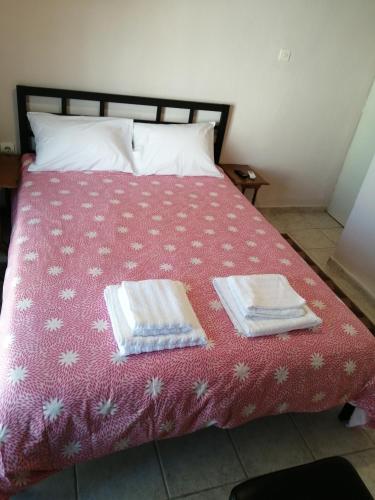uma cama com duas toalhas em cima em Dimitris em Trikala