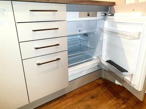 een lege koelkast met open deur bij Suite De Brinkparel in De Koog