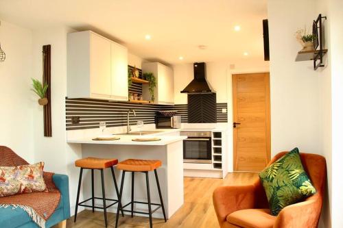a kitchen with a counter and two bar stools at The Coastal Retreat (Nr Brighton) in Peacehaven