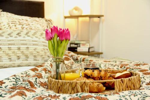 a tray of food and flowers on a bed at The Coastal Retreat (Nr Brighton) in Peacehaven