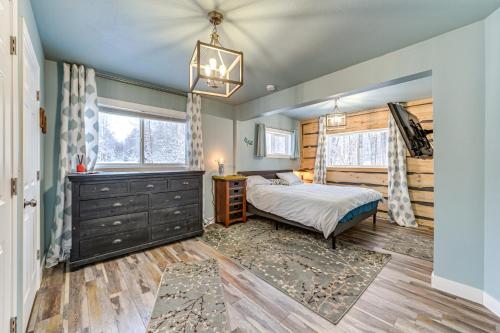 a bedroom with a bed and a dresser and two windows at Spacious Kenai Vacation Rental with Lake Access! in Kenai