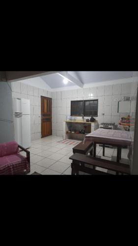 eine Küche mit einem Tisch und einem Kühlschrank in der Unterkunft Casa Itamambuca in Ubatuba