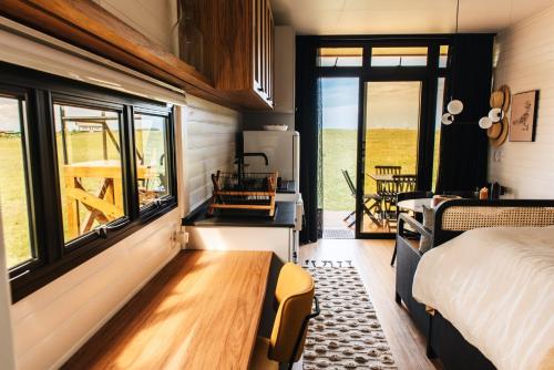 um quarto com uma cama, uma janela e uma mesa em Tiny House Purunã - Refúgio Inspirador em Balsa Nova