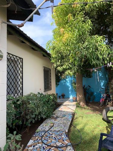 a stone walkway next to a house with a tree at Banana Republic in Old Yundum