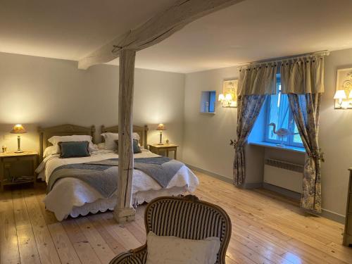 ein Schlafzimmer mit einem Himmelbett und einem Fenster in der Unterkunft Domaine de la Creuse in Moussey