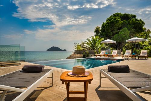 a resort with a swimming pool and the ocean at Violet Beach Front Private Villa in Laganas