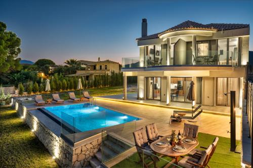 a house with a swimming pool in front of it at Violet Beach Front Private Villa in Laganas