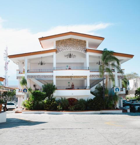 a large white building with a parking lot at María Isabel Colima in Colima