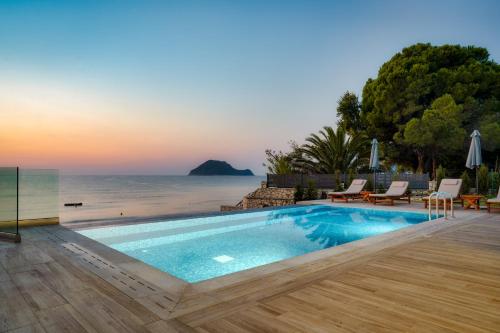 a swimming pool with a view of the ocean at Violet Beach Front Private Villa in Laganas
