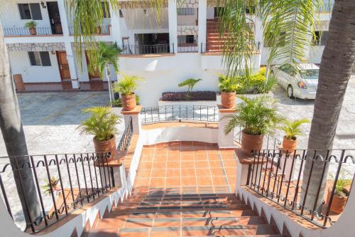 an apartment building with palm trees and a staircase at María Isabel Colima in Colima
