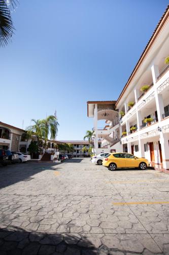 a yellow car parked in a parking lot in front of a building at María Isabel Colima in Colima