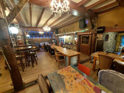 a dining room with tables and chairs and a chandelier at De Linde, boerderij in Drenthe voor 15 tot 30 personen in Linde