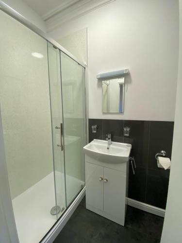 a bathroom with a sink and a glass shower at The Winchester in Great Yarmouth