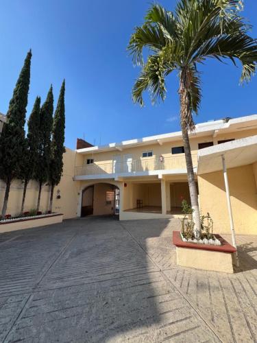 ein Gebäude mit einer Palme davor in der Unterkunft Hotel 20 De Julio in Cuernavaca