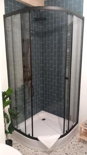 a shower with a glass enclosure in a bathroom at Domek Wonkopianka in Grywałd