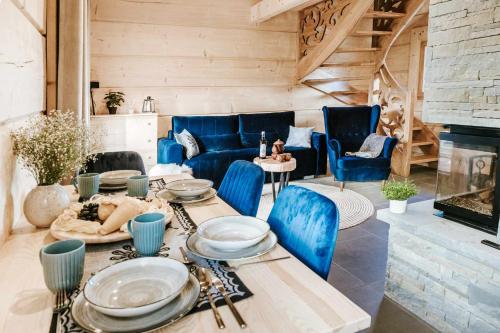 a living room with a table and blue chairs at Chałpy Pod Ostryszem in Ciche