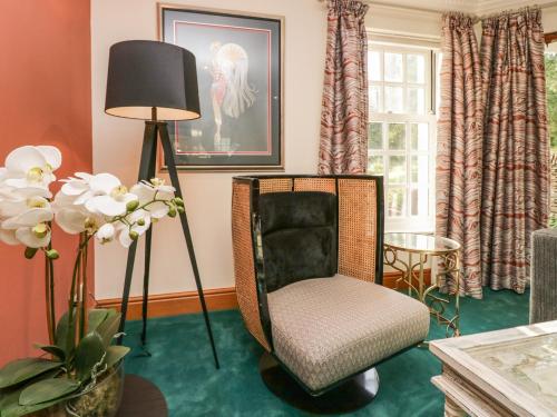 a living room with a chair and a lamp at Lakeside View in Ulverston
