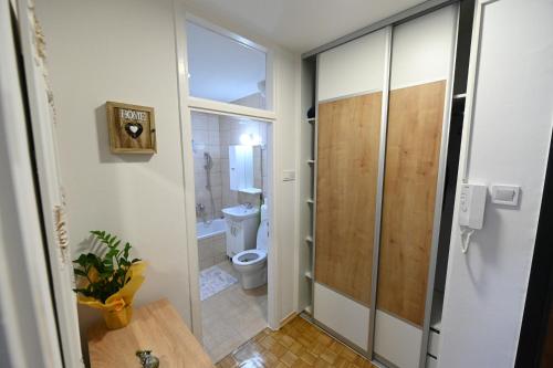 a bathroom with a toilet and a glass door at Apartman N&D in Banja Luka