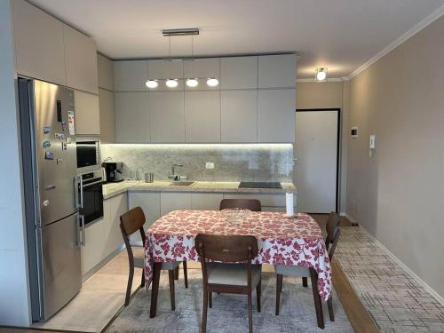 ティラナにあるEden Central Apartment - Modern 2BR in Tirana City Centerのテーブルと椅子、冷蔵庫のあるキッチン