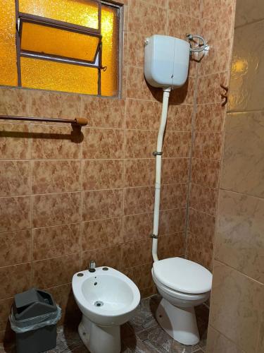 a bathroom with a toilet and a sink at Residencial Arcoiris in Puerto Iguazú